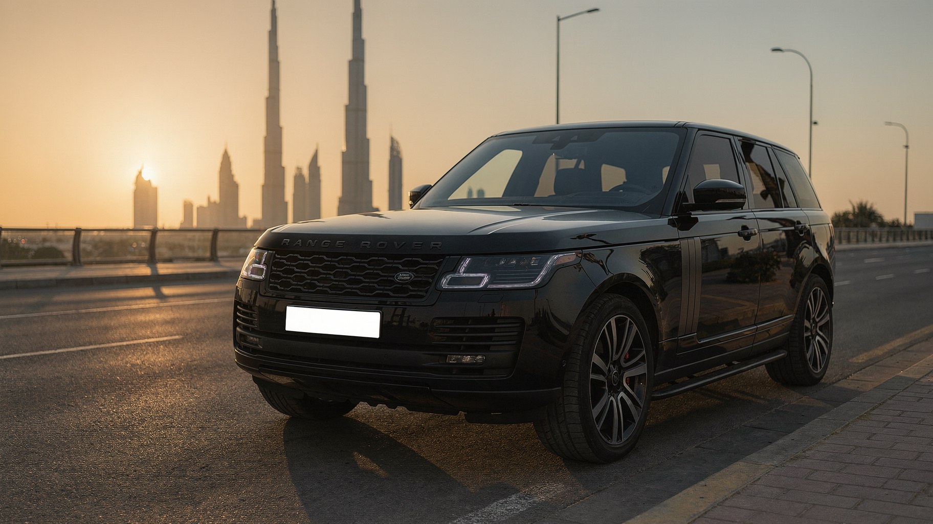 Black Range Rover delivered to the kerb on a Downtown Dubai street at sunset