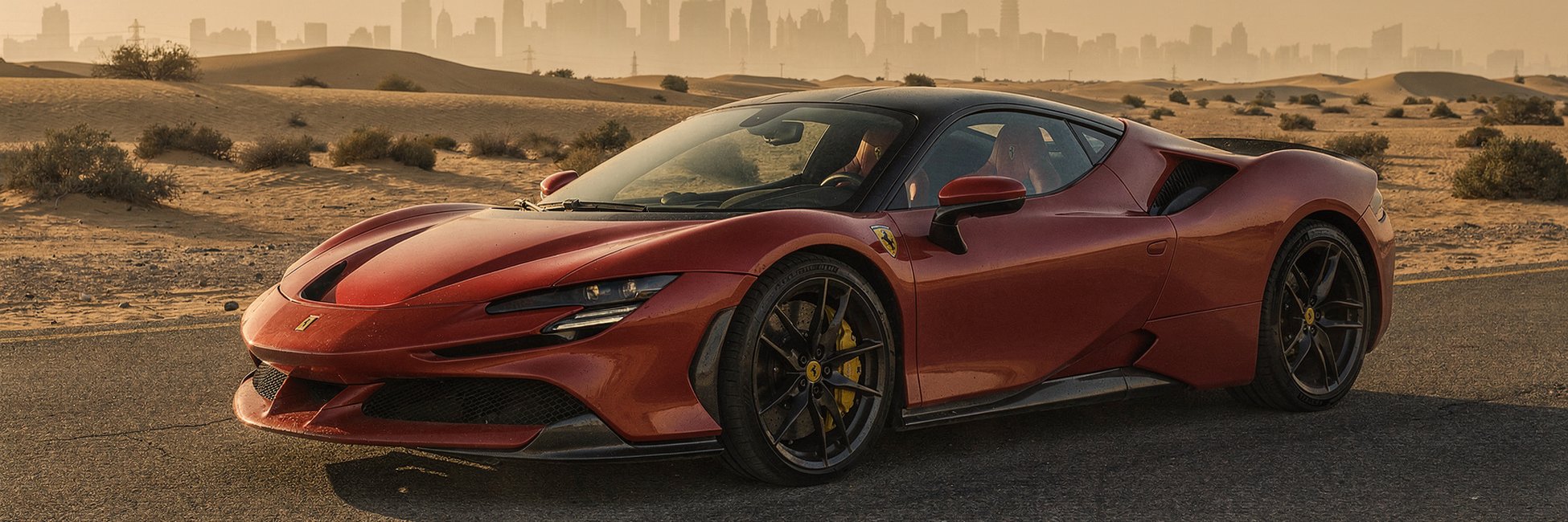 Ferrari SF90 on a desert road with the Dubai skyline behind